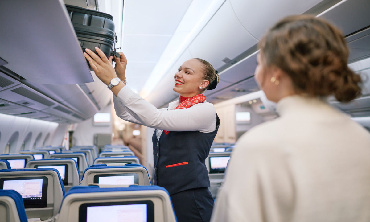 Flight Attendant verstaut Handgepäck