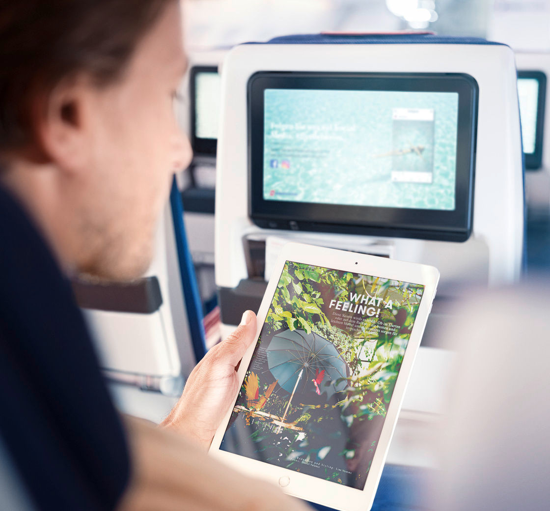 Homme lisant le journal électronique à bord