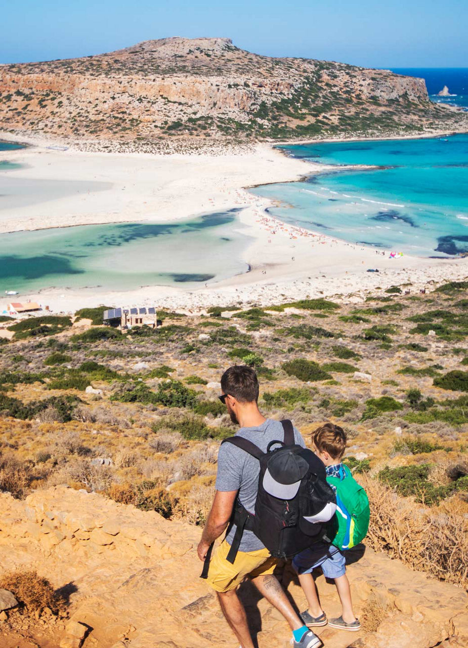 Father and son hiking down to beach