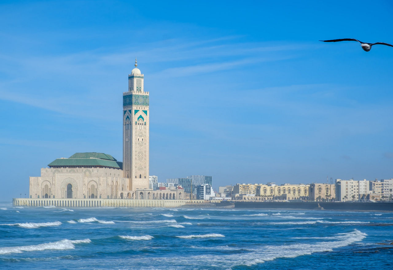 Meer mit Schaumkronen im Vordergrund und die Moschee im Hintergrund