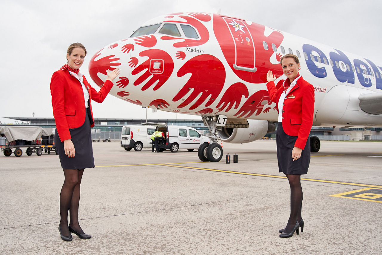 Flight attendant in front of our painted Help Alliance plane