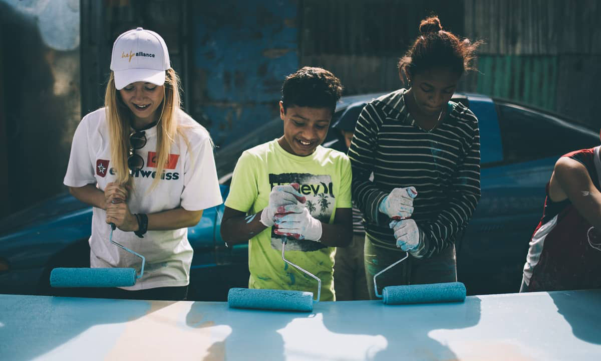 three people painting a large area