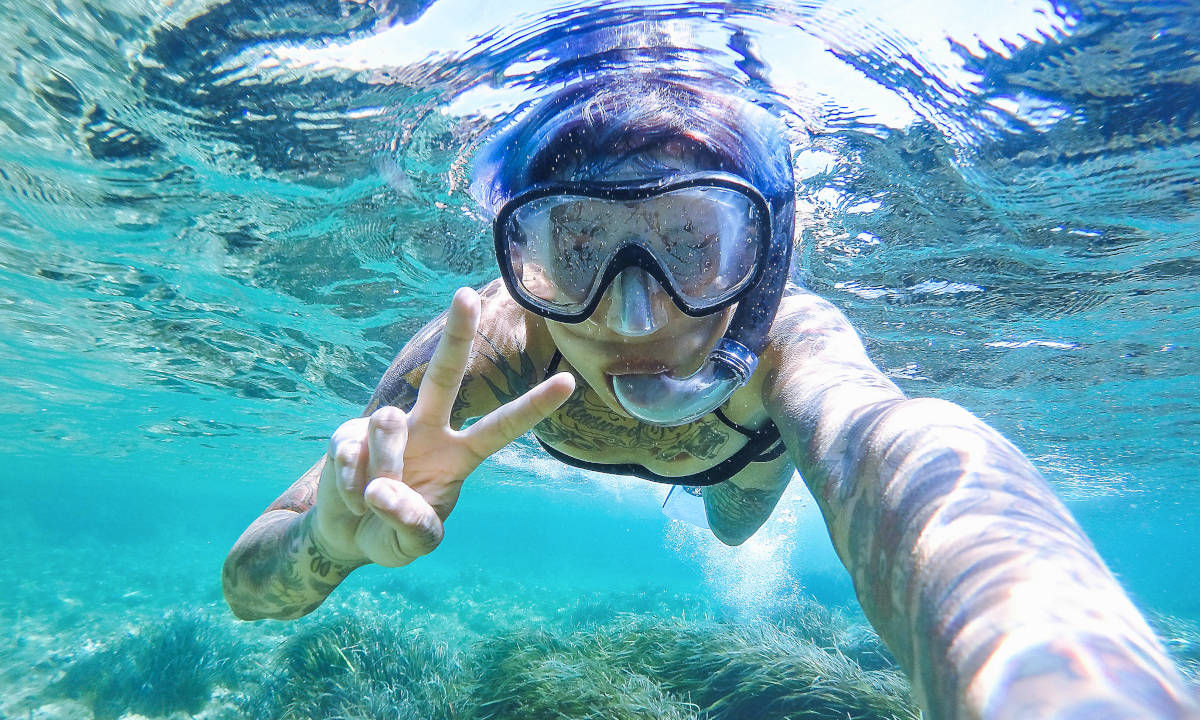 A snorkeller making the peace sign