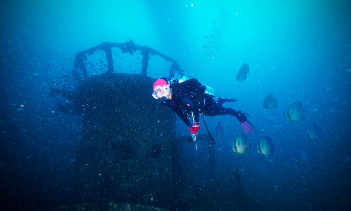 A female Tec diver swimming around a control tower.