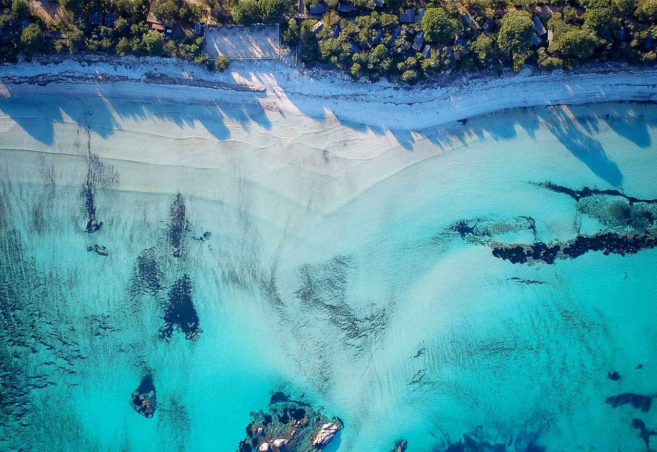 Kristallklares Wasser und weisser Sandstrand  aus der Vogelperspektive