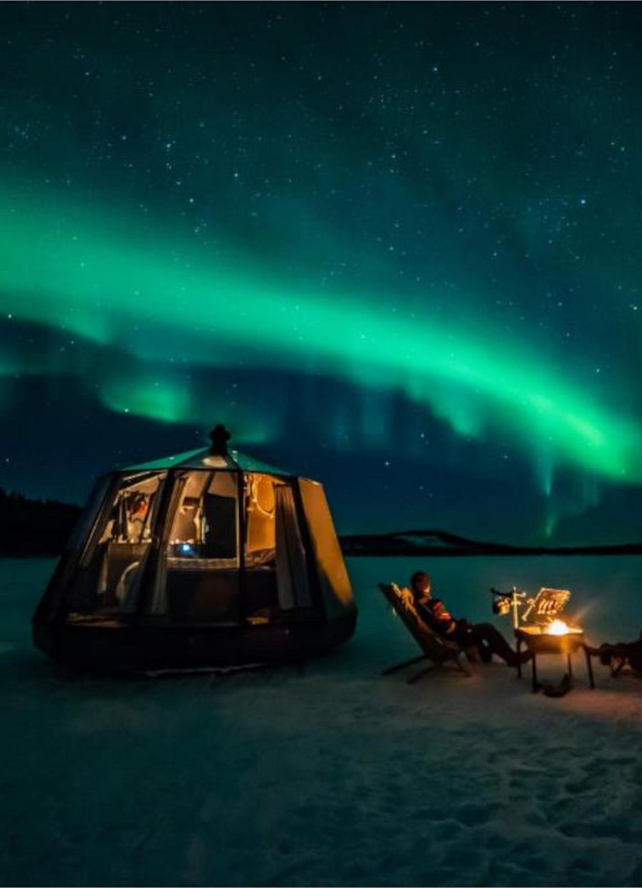 Log cabin under the Aurora Borealis