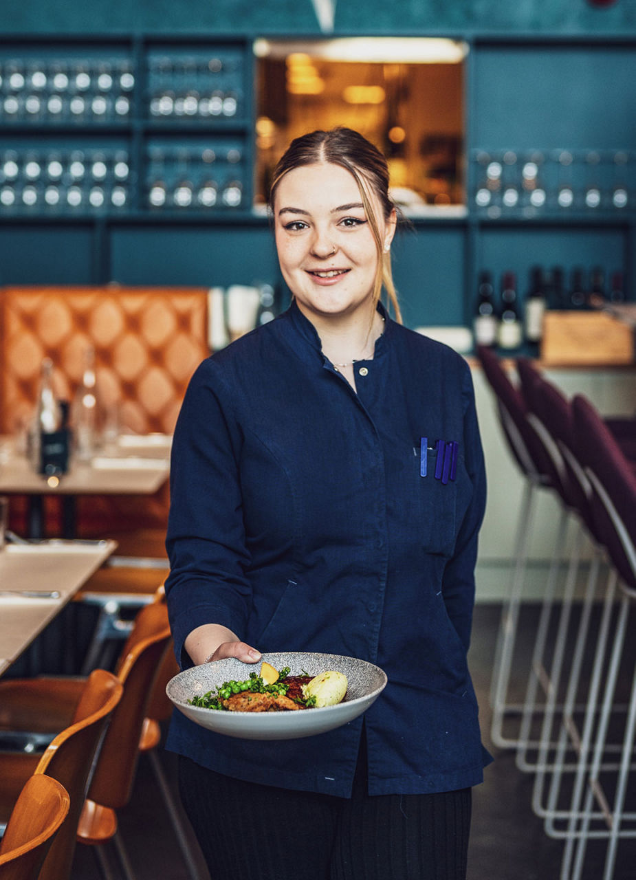 Servicemitarbeiterin präsentiert Essen in einem Bistro