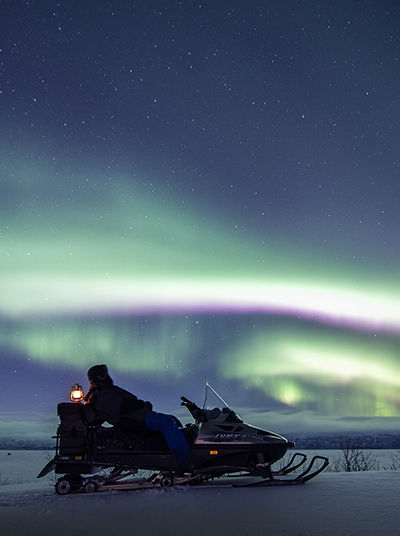 Snowmobile in front of the Northern Lights