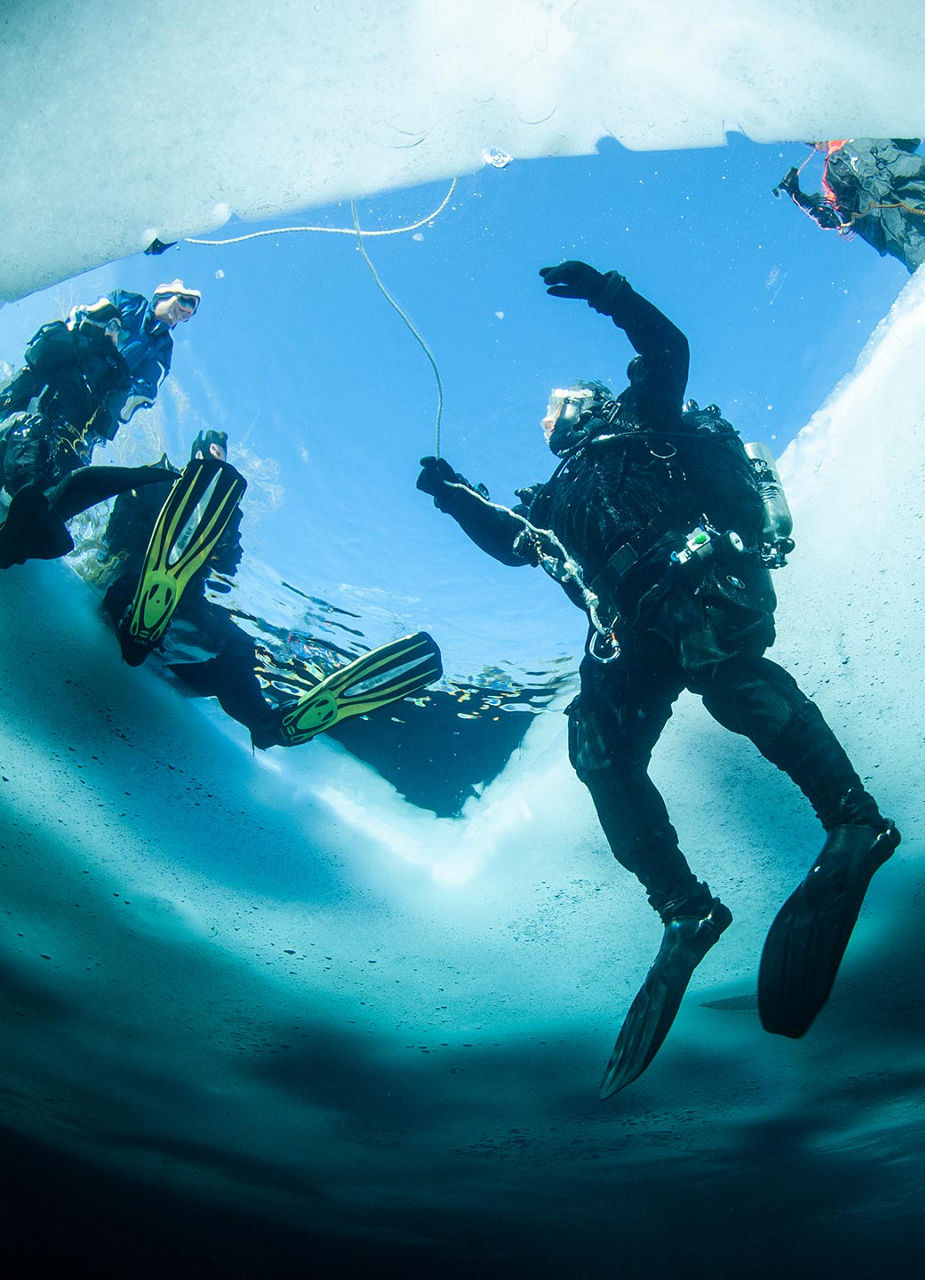 Taucher beim Einstieg im Eisloch
