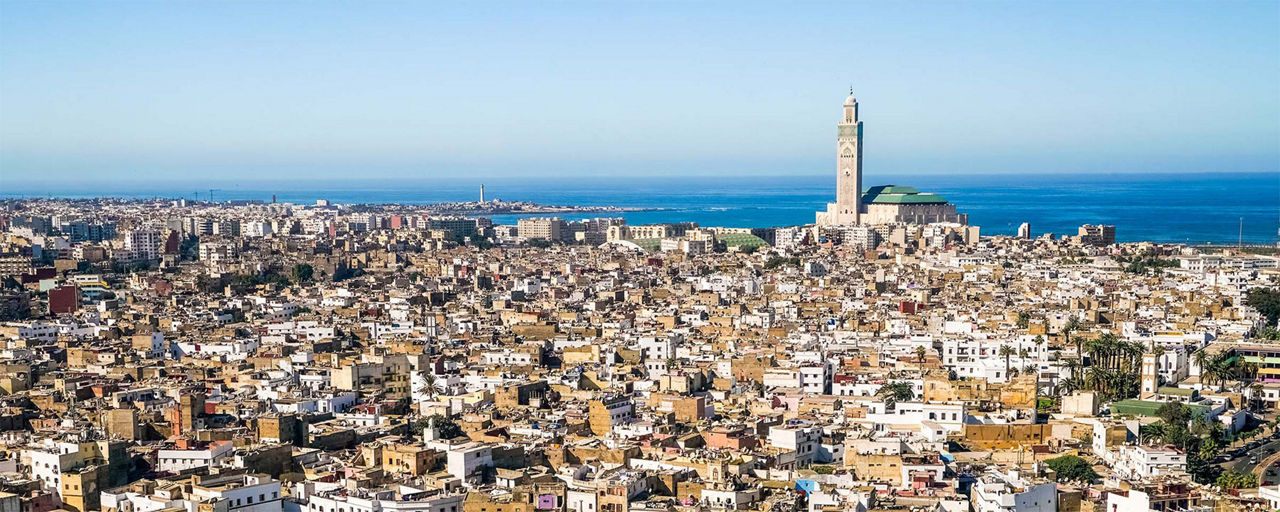 Blick über Casablanca mit Meer und Moschee im Hintergrund