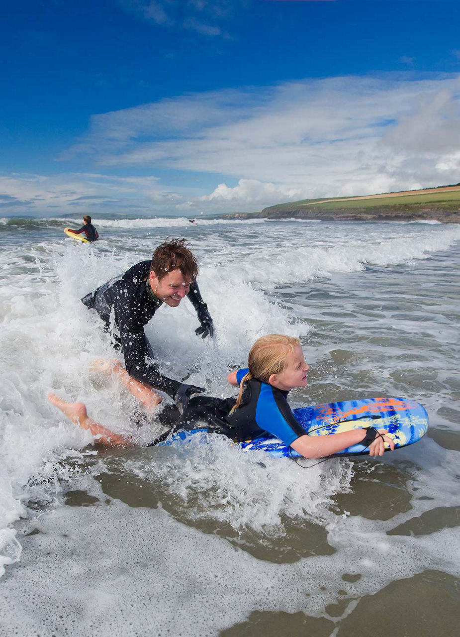 Father and son surfing the wave