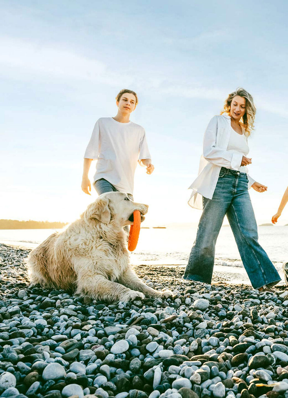 Famille avec chien sur la plage de galets de Por do Sol