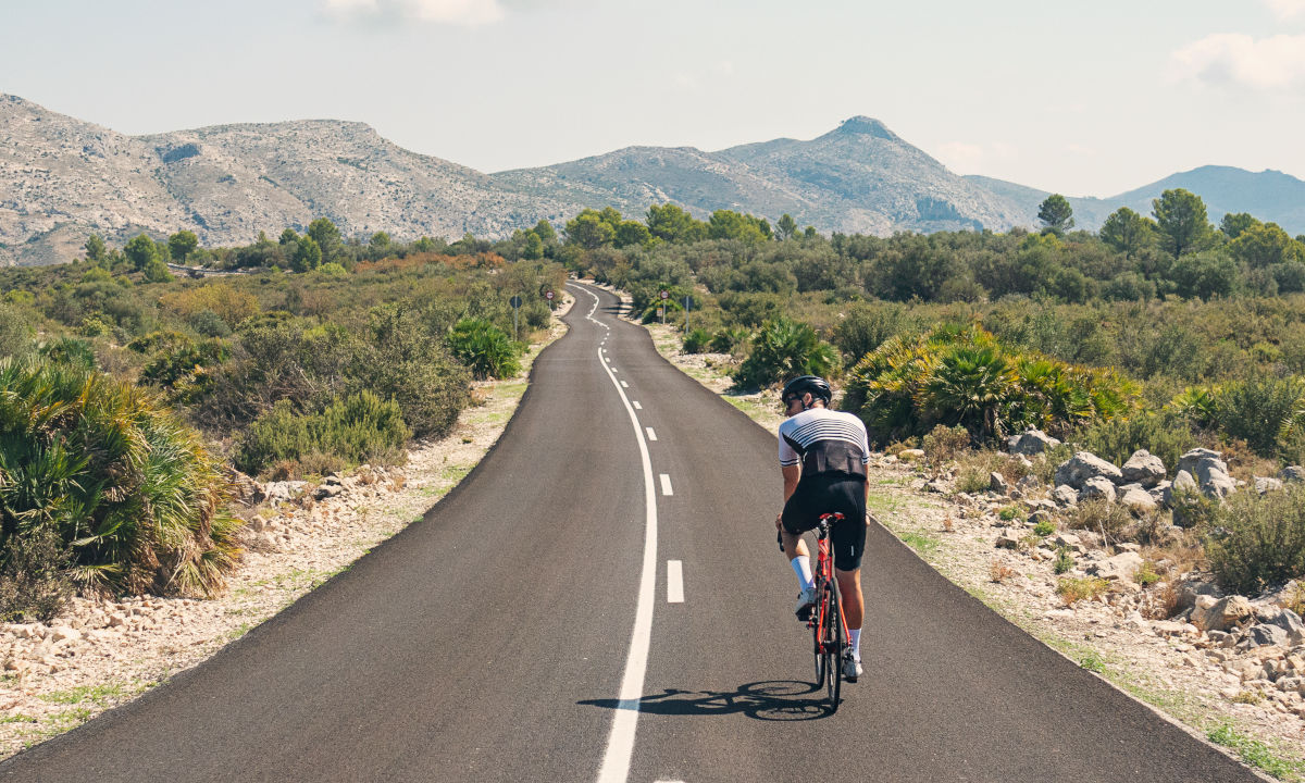 Road cyclist on a long road