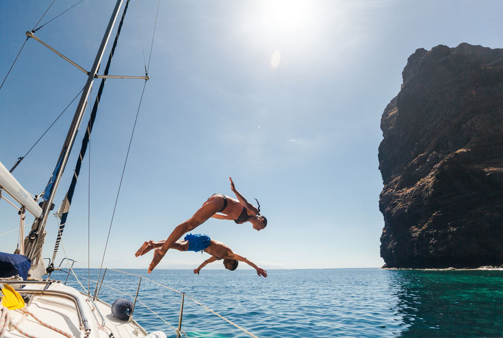 Kinder springen von einem Boot in Spanien
