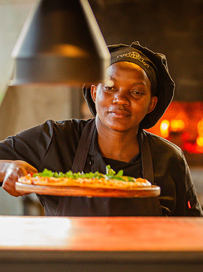 Köchin mit Pizza im Birdcage