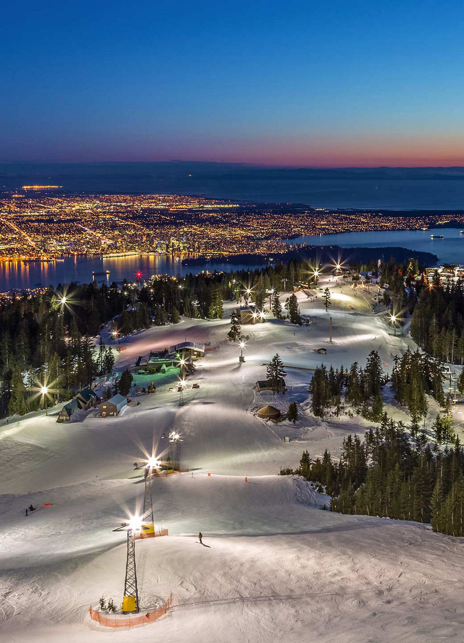 Sunset ski slope and view of the city