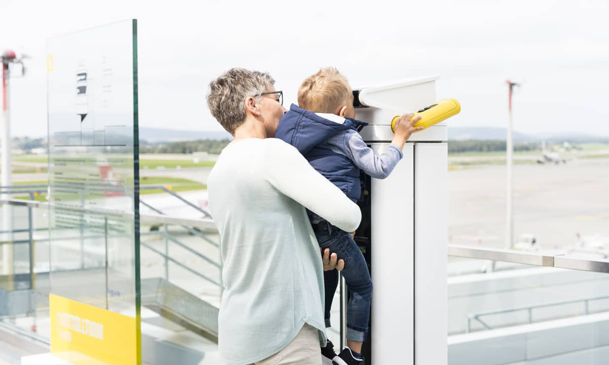  Woman with child watching airplanes on the viewing terrace